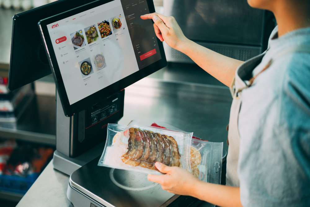Waiter using Azmi POS tablet for table-side billing in a restaurant